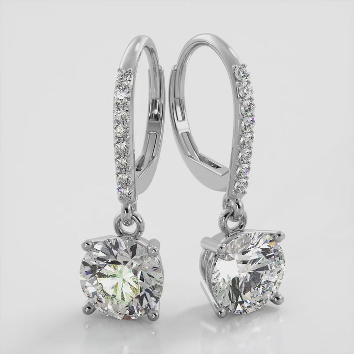 18K White Gold, Classic Brilliant Diamond Drop Earrings with a secure lever back locking mechanism and sparkling round diamonds. These earrings will add a touch of glamour to any outfit. Elevate your style and make a statement with these stunning earrings.